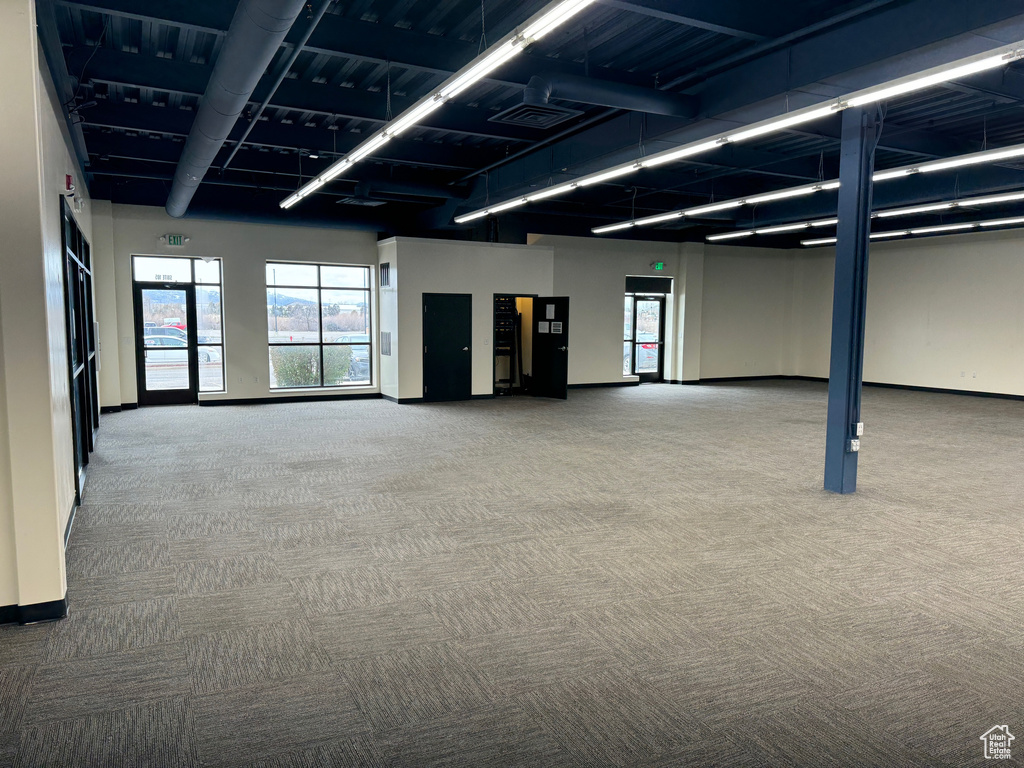 Interior space with visible vents, baseboards, carpet, and a healthy amount of sunlight