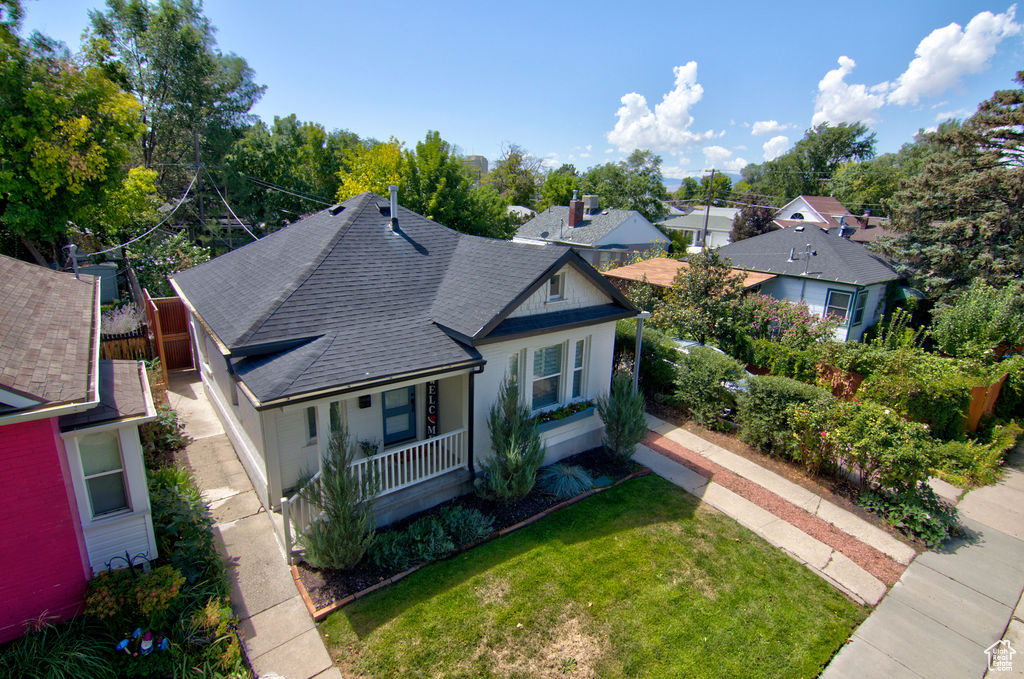 View of front of house featuring a porch, a front lawn, and a shingled roof