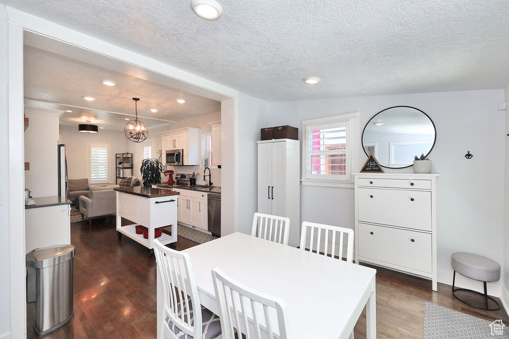 Dining space featuring a textured ceiling, dark wood-style floors, plenty of natural light, and recessed lighting
