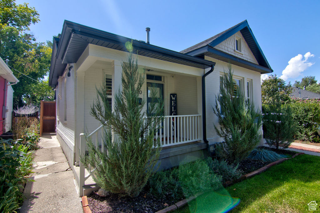 View of front of house featuring brick siding and a porch