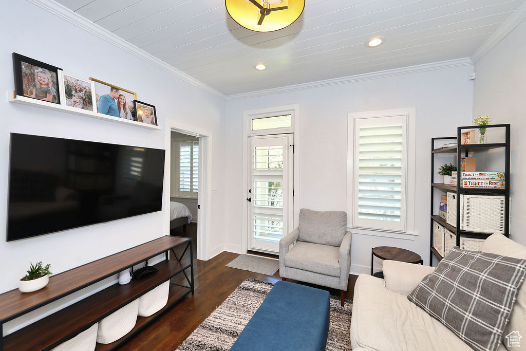 Living area featuring crown molding, baseboards, recessed lighting, and dark wood-style floors