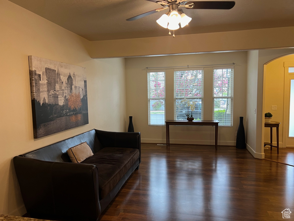 Living area featuring a healthy amount of sunlight, arched walkways, and wood finished floors