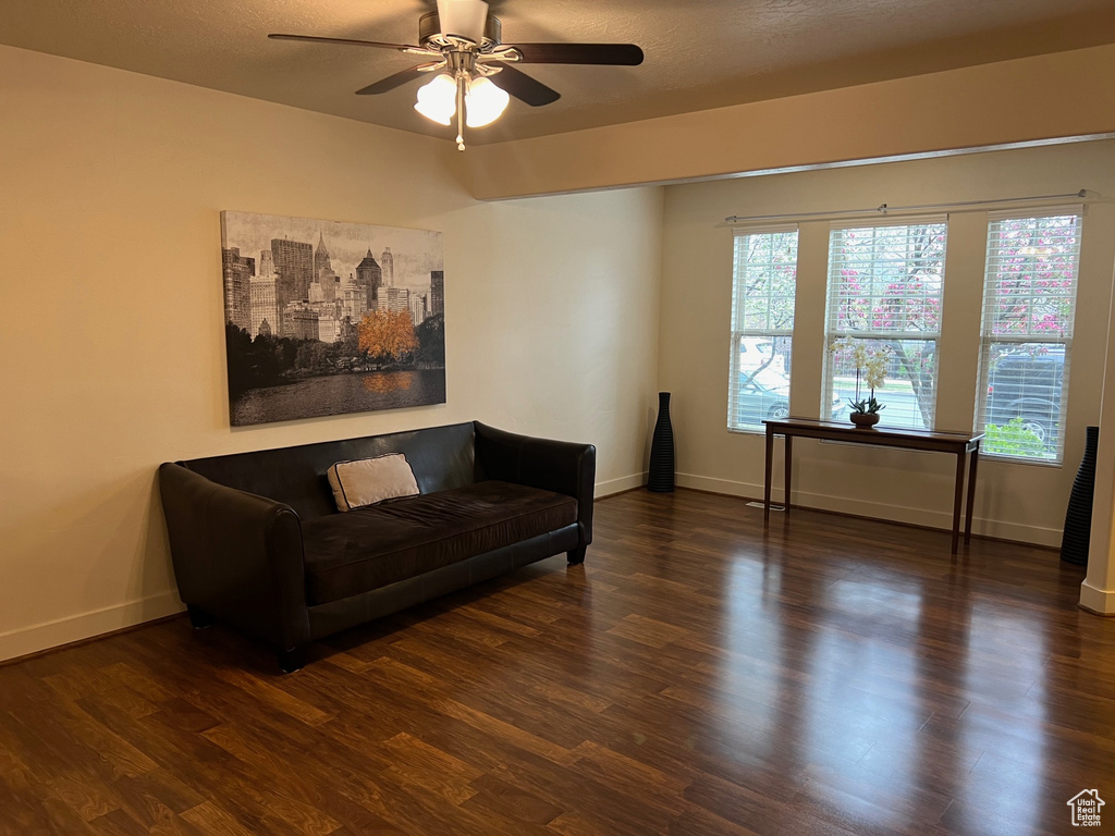 Living room featuring baseboards, a ceiling fan, and wood finished floors