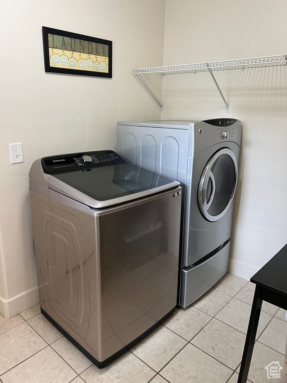 Laundry area featuring light tile patterned floors, baseboards, laundry area, and independent washer and dryer