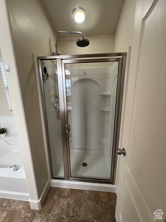 Full bathroom with baseboards, a shower stall, and a garden tub