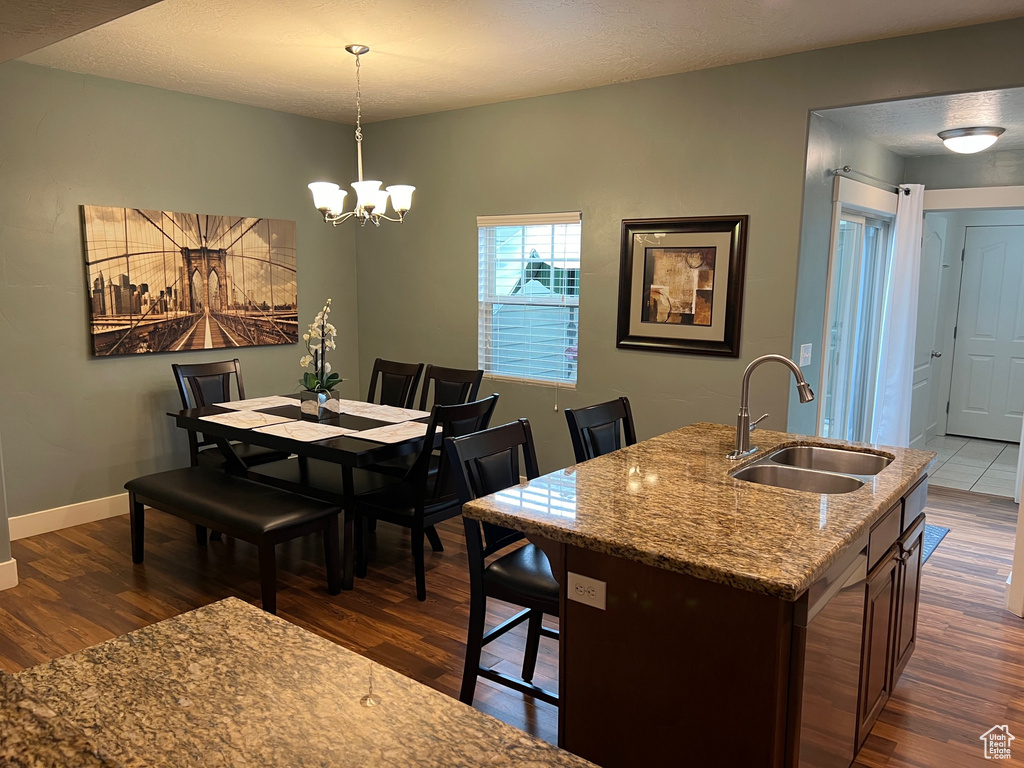 Dining area featuring a chandelier, baseboards, and dark wood finished floors