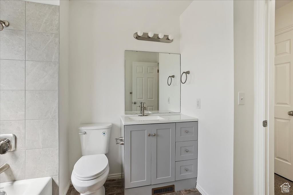Bathroom featuring toilet, visible vents, vanity, and baseboards
