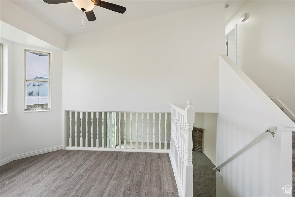 Interior space with baseboards, visible vents, wood finished floors, and a ceiling fan