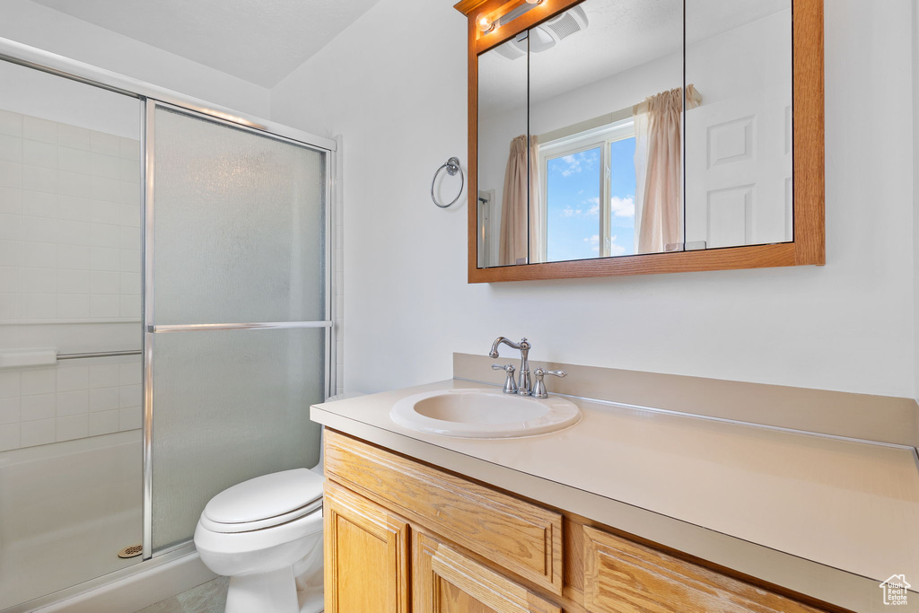 Full bath with toilet, a shower stall, and vanity