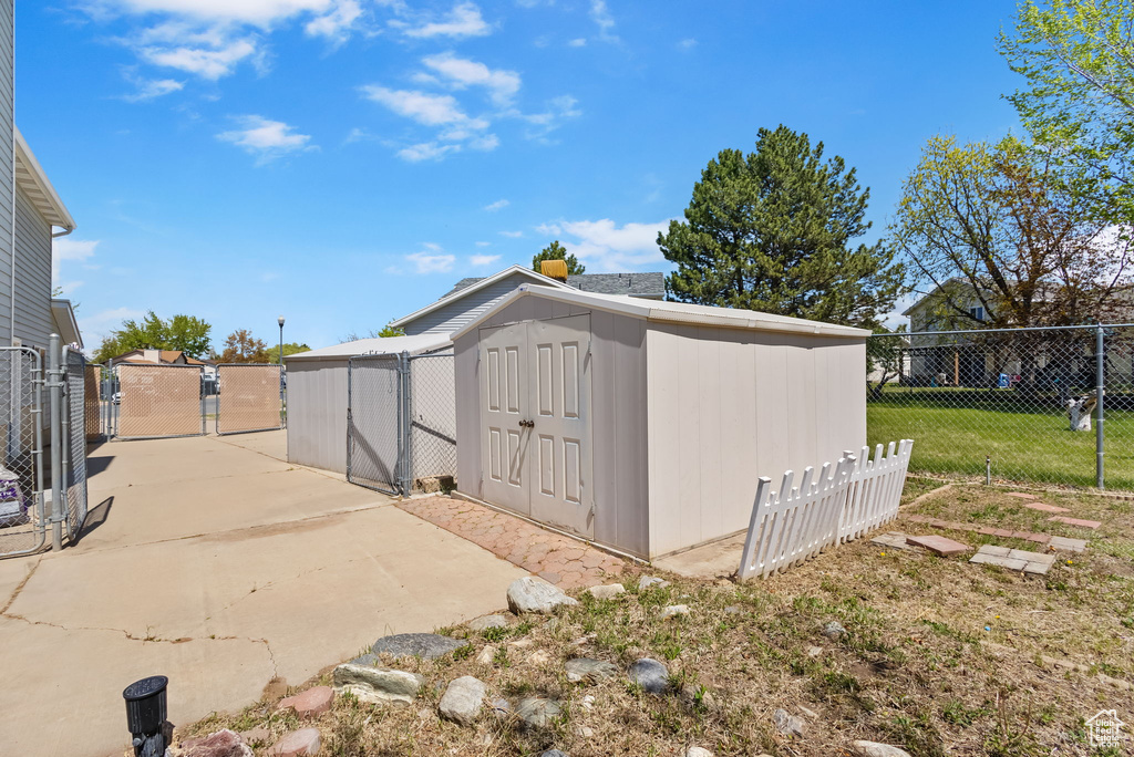 View of shed featuring fence and a gate