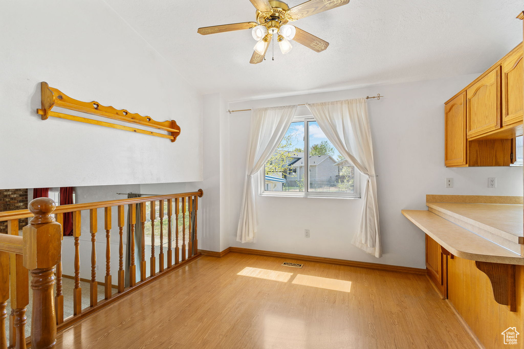 Interior space with visible vents, light wood-type flooring, ceiling fan, and baseboards