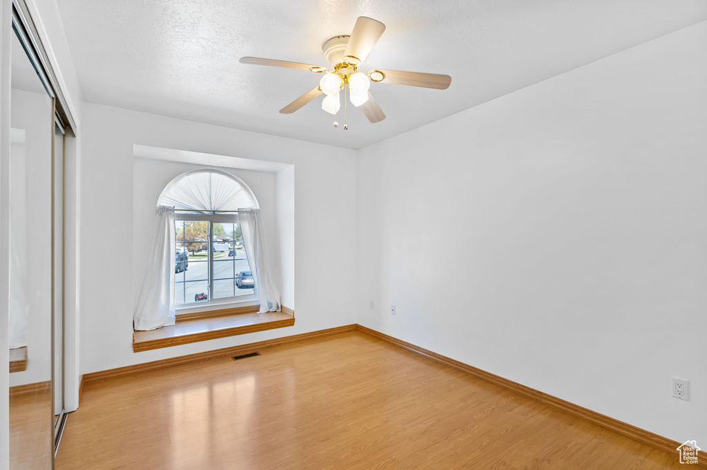 Spare room featuring wood finished floors, visible vents, and baseboards