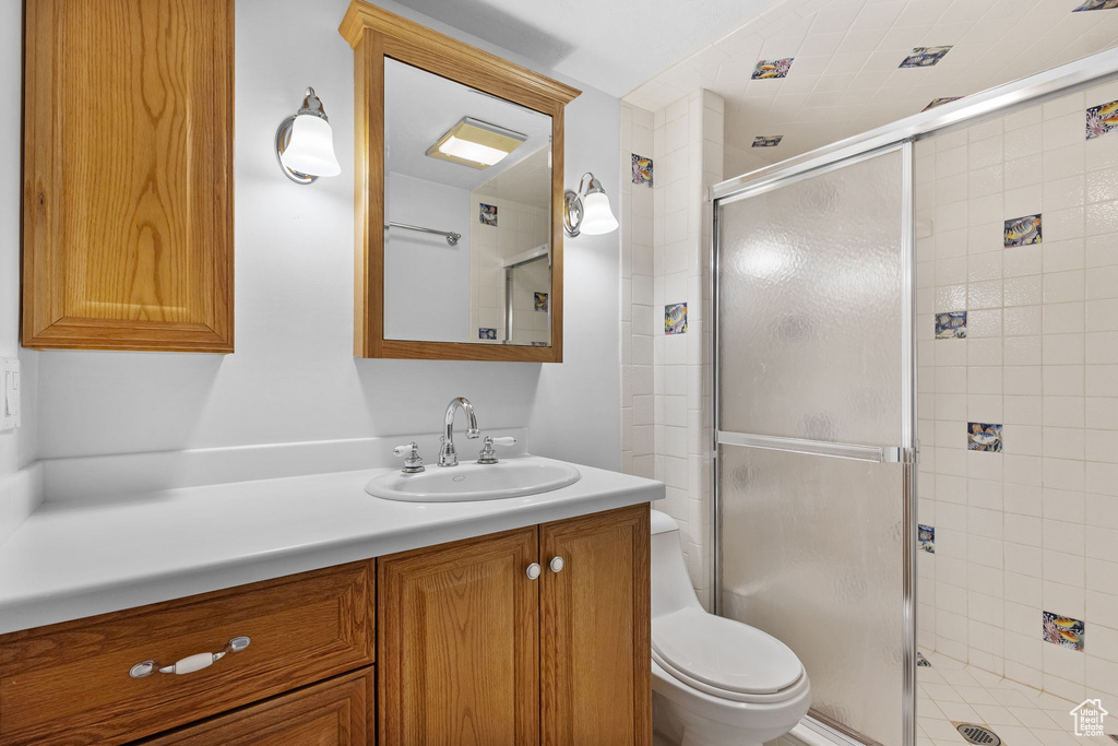 Bathroom with a shower stall, toilet, and vanity