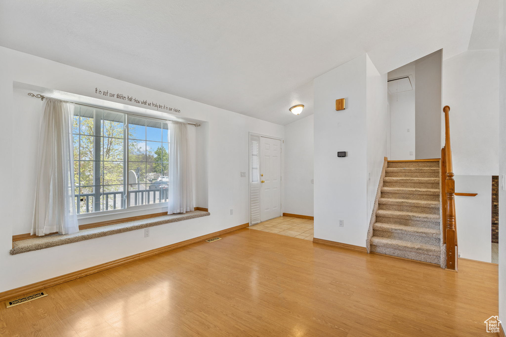Interior space featuring baseboards, visible vents, wood finished floors, and stairs