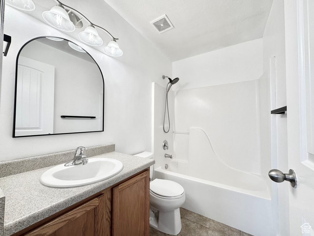 Bathroom featuring tile patterned flooring, toilet, vanity, visible vents, and tub / shower combination