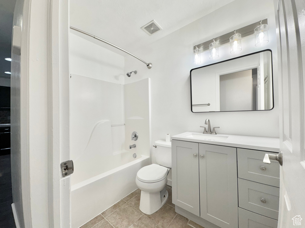 Bathroom with vanity, bathing tub / shower combination, toilet, visible vents, and tile patterned flooring