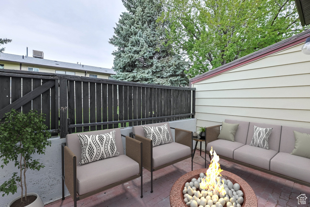 View of patio / terrace featuring an outdoor living space with a fire pit and fence