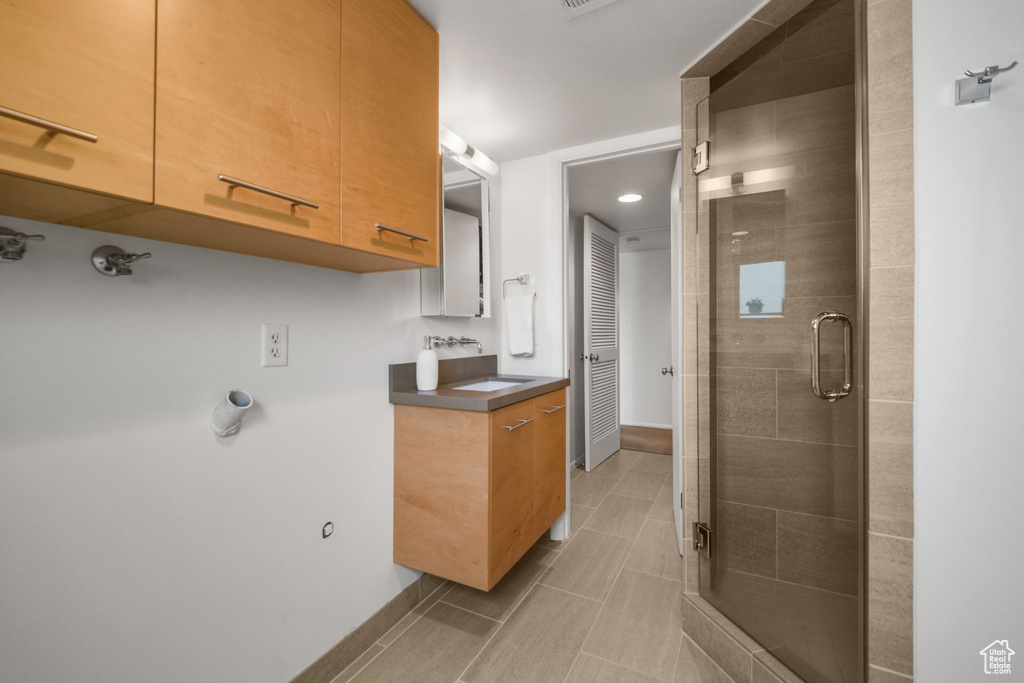 Full bathroom with baseboards, a stall shower, tile patterned floors, and vanity