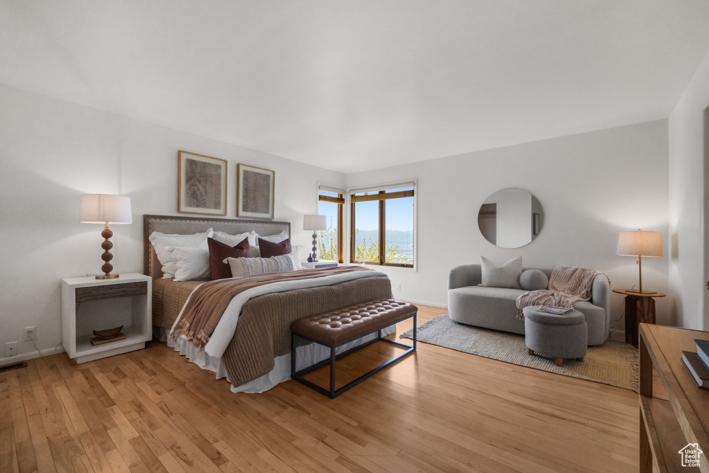 Bedroom with visible vents, light wood-style flooring, and baseboards