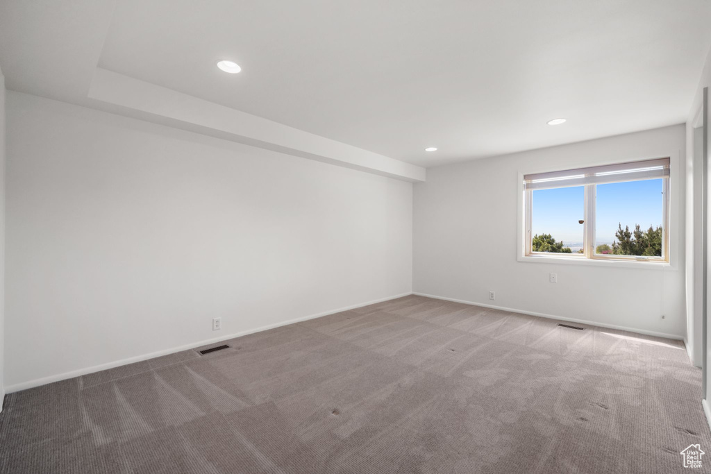 Carpeted spare room featuring recessed lighting, visible vents, and baseboards