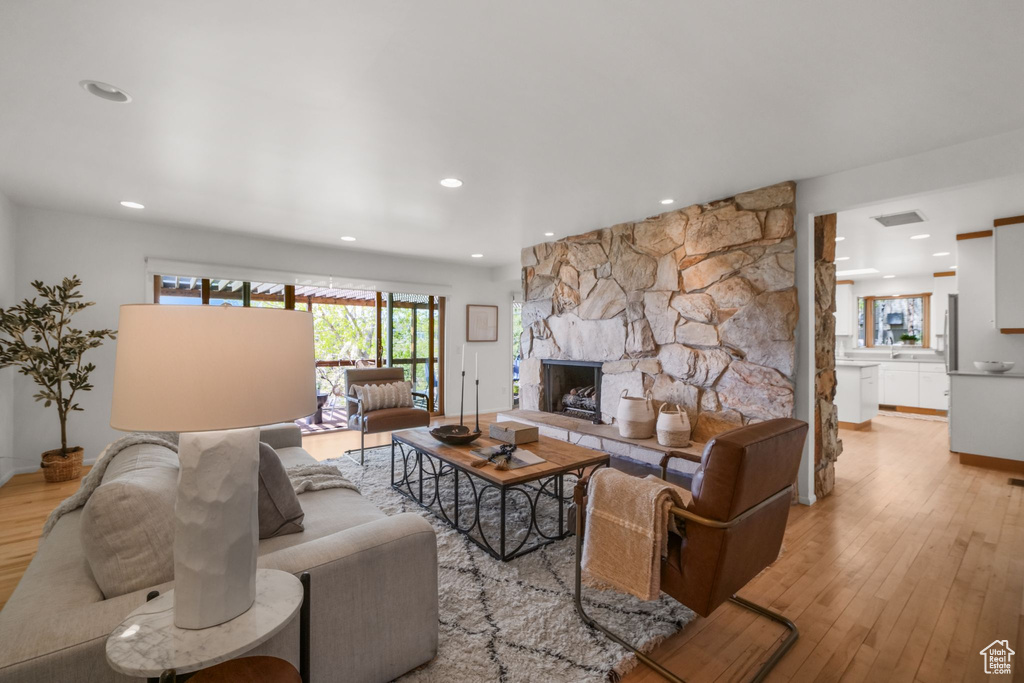Living room featuring recessed lighting, a fireplace, light wood-type flooring, visible vents, and baseboards