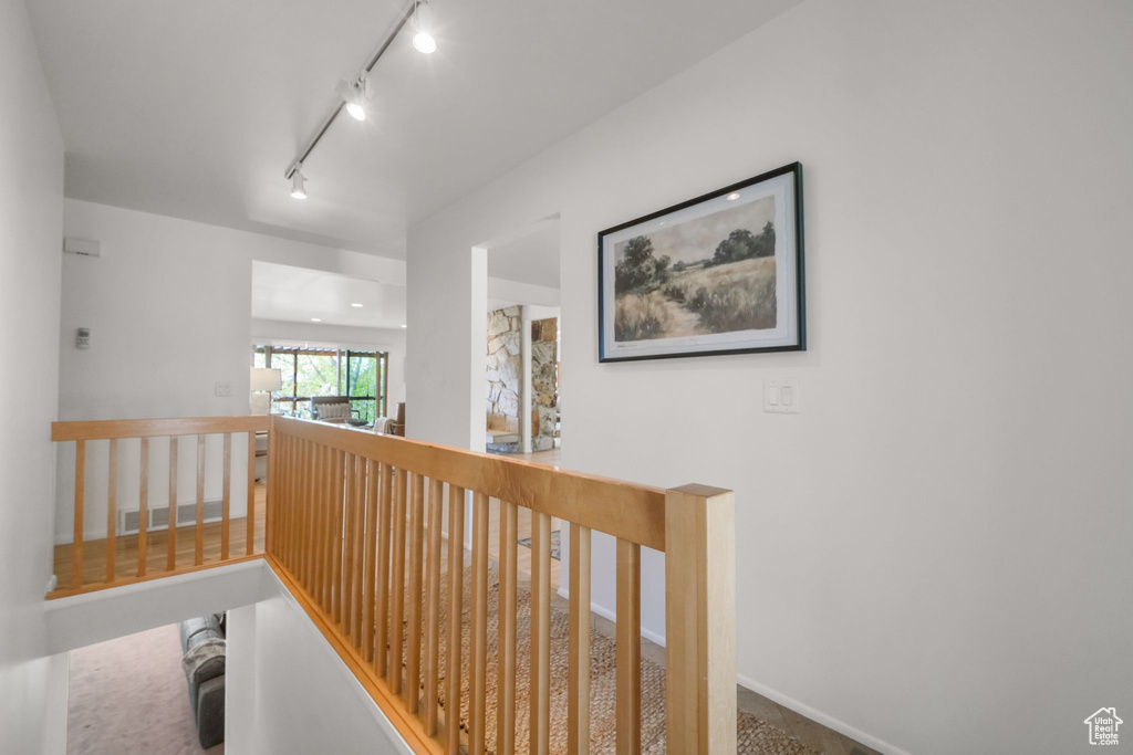 Hall with track lighting and an upstairs landing