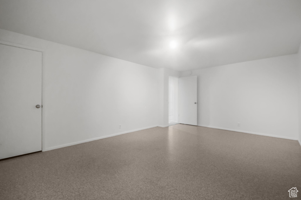 Empty room featuring baseboards and speckled floor
