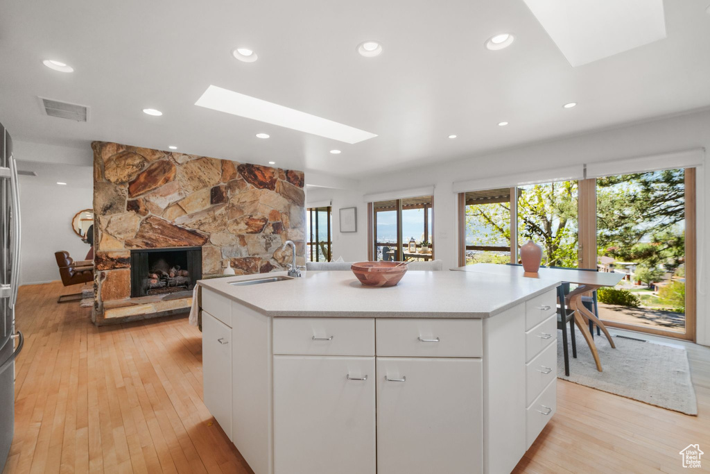 Kitchen with visible vents, a skylight, a fireplace, and a sink