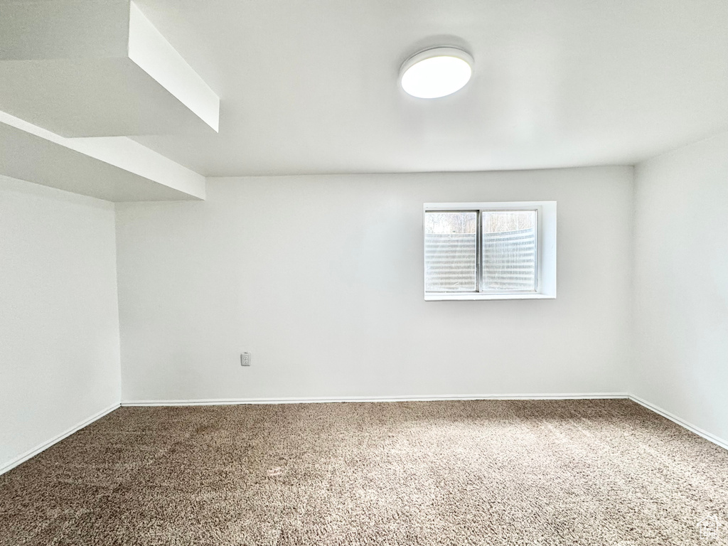 Empty room featuring baseboards and carpet floors