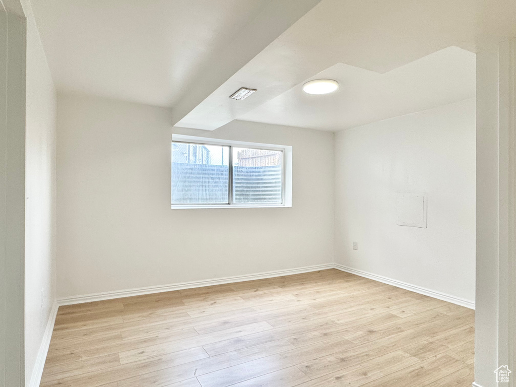 Unfurnished room with light wood-style floors and baseboards