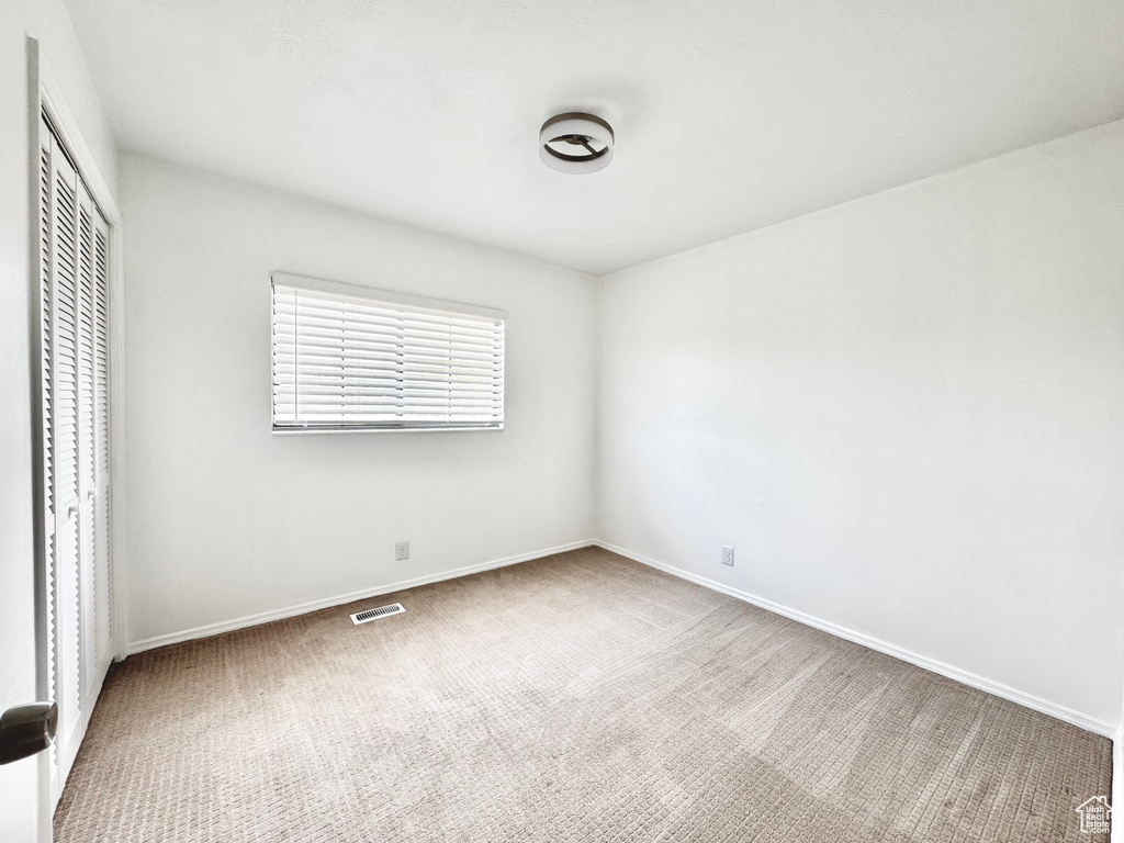 Unfurnished bedroom featuring baseboards, visible vents, a closet, and carpet flooring