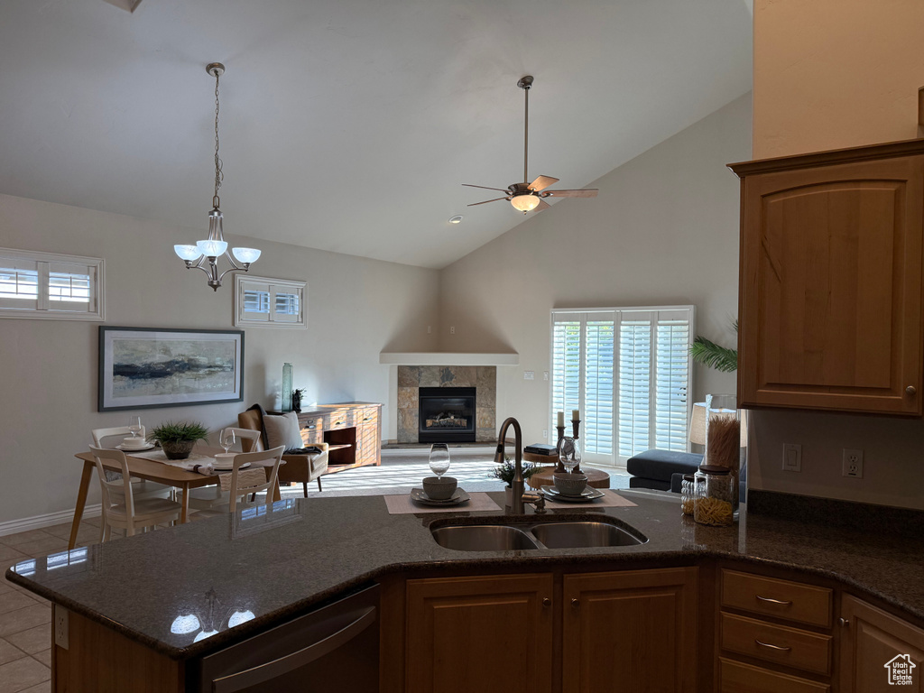 Kitchen featuring a sink, plenty of natural light, dark stone countertops, and high vaulted ceiling