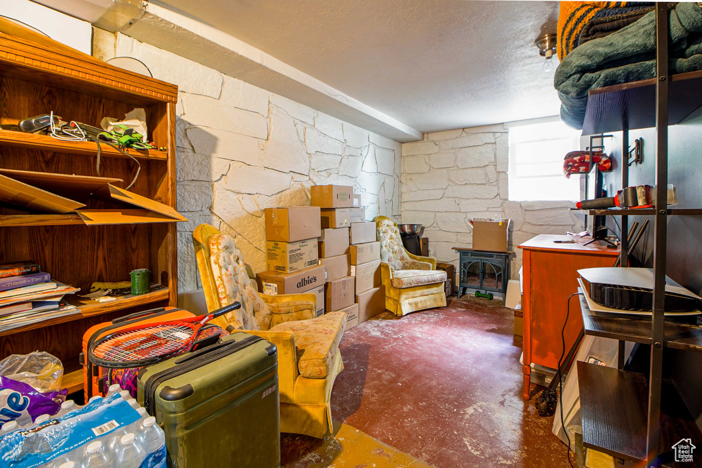Basement with a textured ceiling and a wood stove
