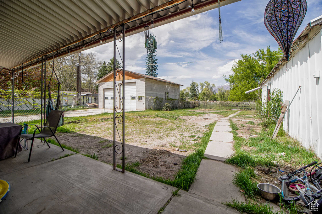 View of yard featuring a patio, a fenced backyard, and an outbuilding