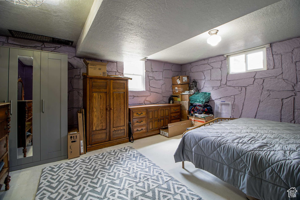 Bedroom featuring a textured ceiling and multiple windows