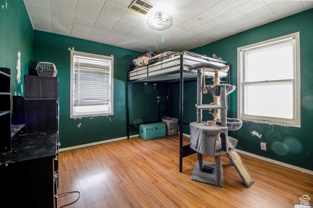Bedroom with visible vents, wood finished floors, and baseboards