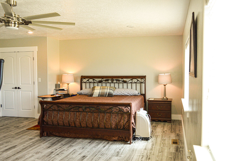 Bedroom featuring a textured ceiling, wood finished floors, and a ceiling fan