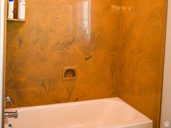Bathroom featuring a textured ceiling and tub / shower combination