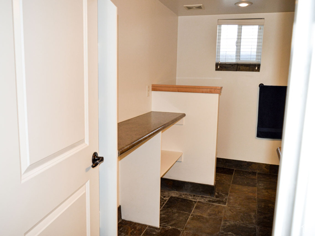 Bathroom featuring stone finish flooring, visible vents, and vanity