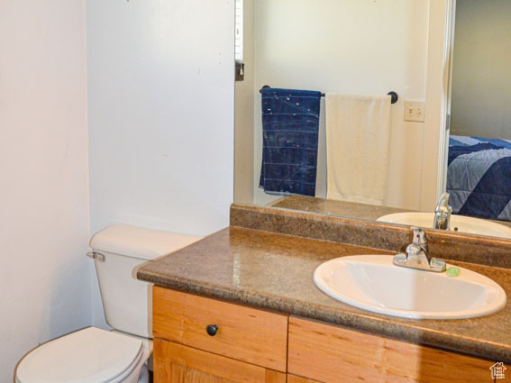 Bathroom featuring toilet, connected bathroom, and vanity