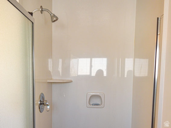 Full bath featuring a textured ceiling and a stall shower