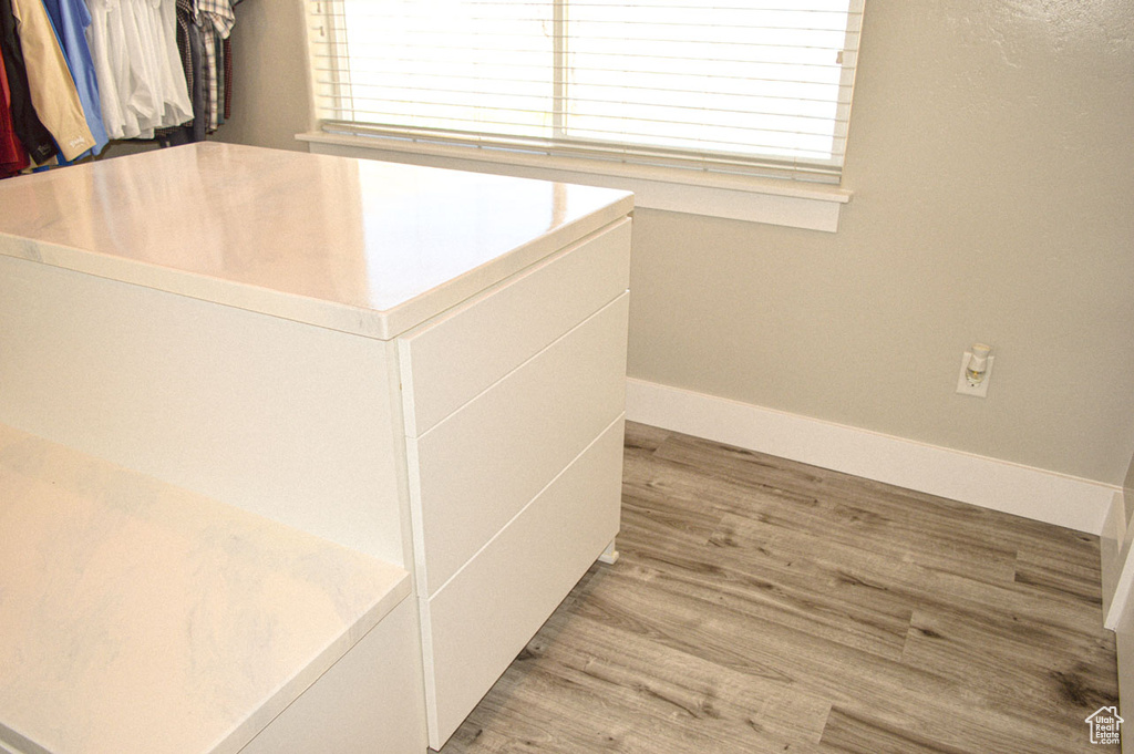 Walk in closet with wood finished floors