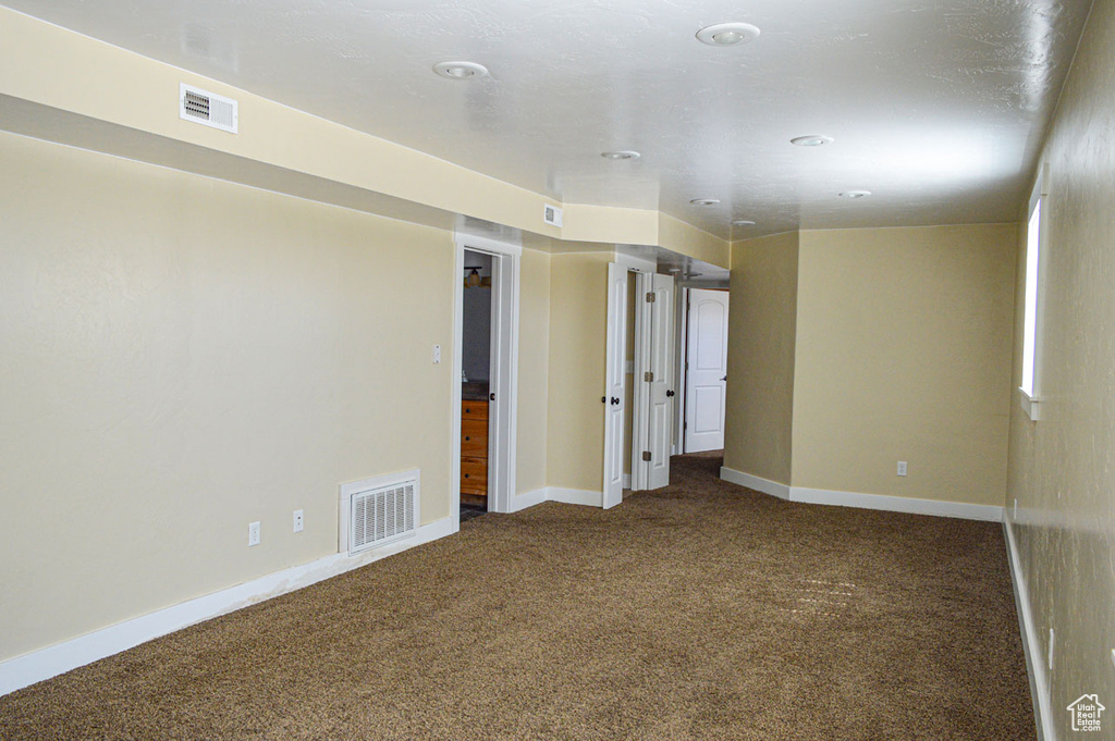 Unfurnished room with carpet, visible vents, and baseboards