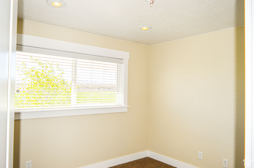 Unfurnished room featuring recessed lighting, a textured ceiling, and baseboards