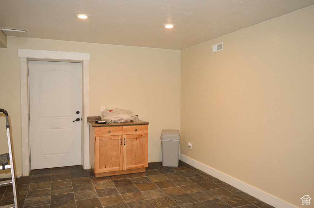 Laundry room with baseboards, visible vents, stone finish floor, and recessed lighting