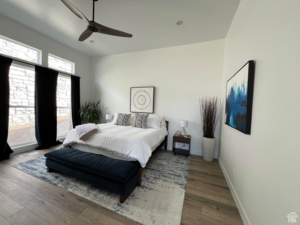 Bedroom featuring baseboards, a ceiling fan, and wood finished floors