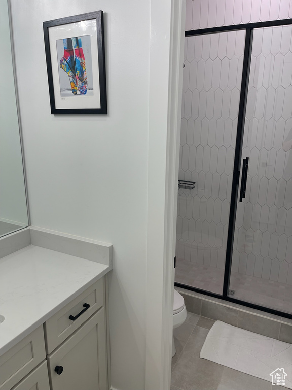 Full bath with toilet, a stall shower, tile patterned flooring, and vanity