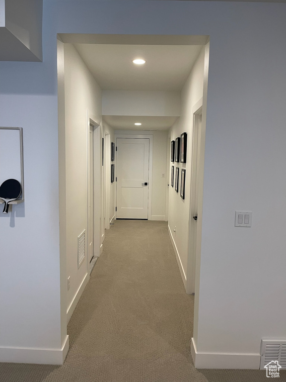 Hallway with baseboards, visible vents, carpet, and recessed lighting