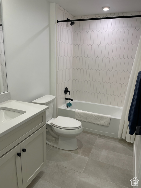 Bathroom with shower / tub combo, vanity, toilet, and tile patterned flooring