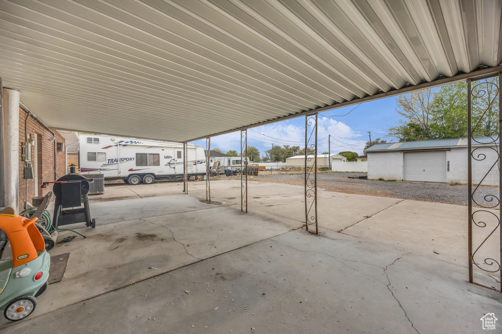 View of patio featuring fence and an outbuilding